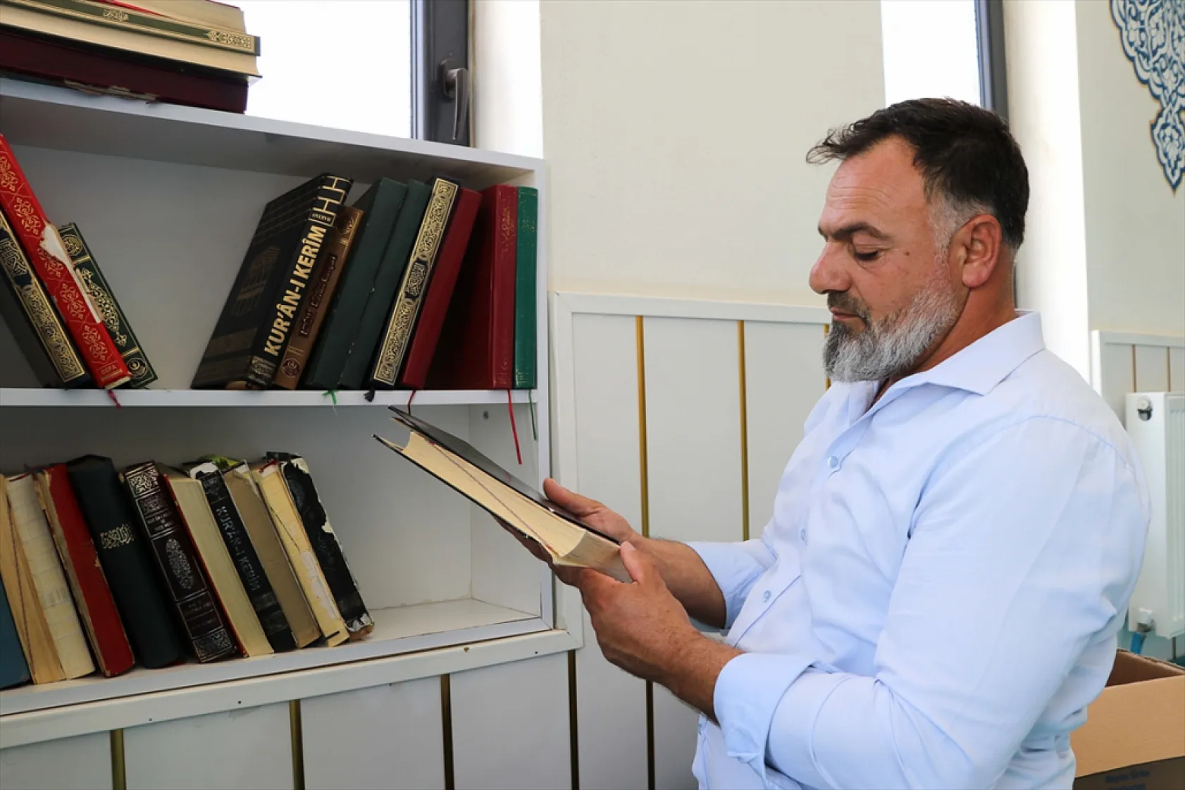 Şehit oğlunun hayrına Kur'an-ı Kerim onarıyor