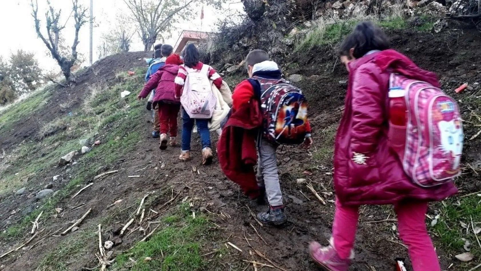 Öğrenciler çamurlu patika yolda okula gidiyor
