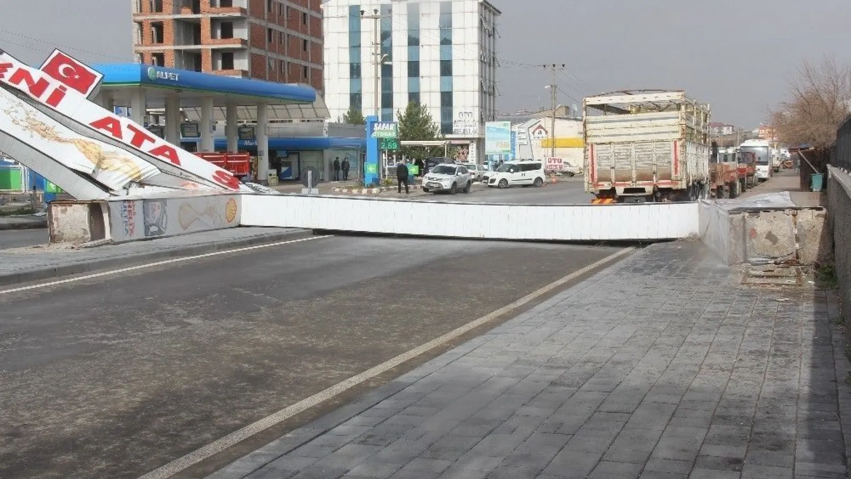 Sivas'ta kuvvetli rüzgarın etkisi ile caddeye devrilen tabela, yolu araç ulaşımına kapattı
