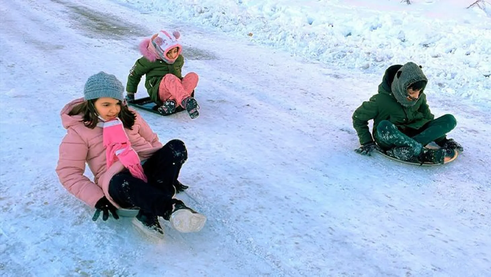 Anneler ve çocukları tepsiyle kayarak kar keyfi yaşadı