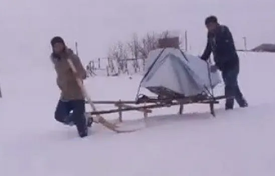 Arızalı bulaşık makinesi, karda kızakla taşındı