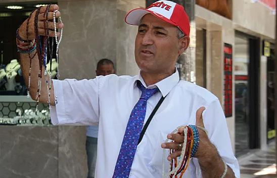 Öğretmen gibi giyinip, tespih satıyor