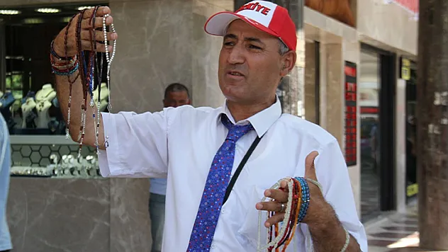Öğretmen gibi giyinip, tespih satıyor