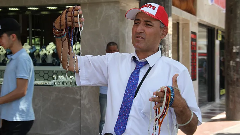 Öğretmen gibi giyinip, tespih satıyor